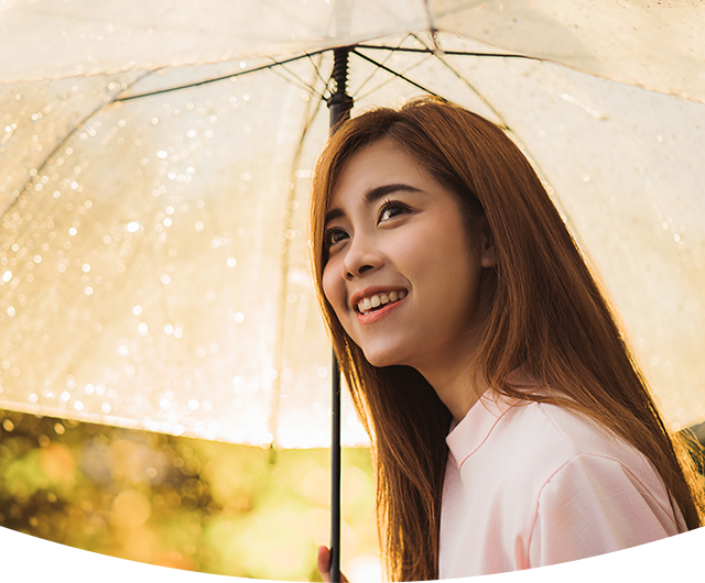 位在雨天撑着伞并面带笑容的年轻女士