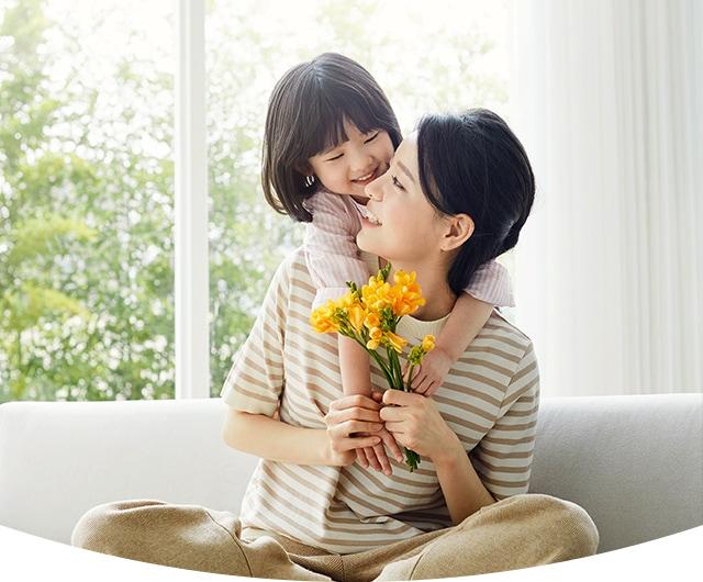 位微笑着的年轻金发女性正背着她的女儿